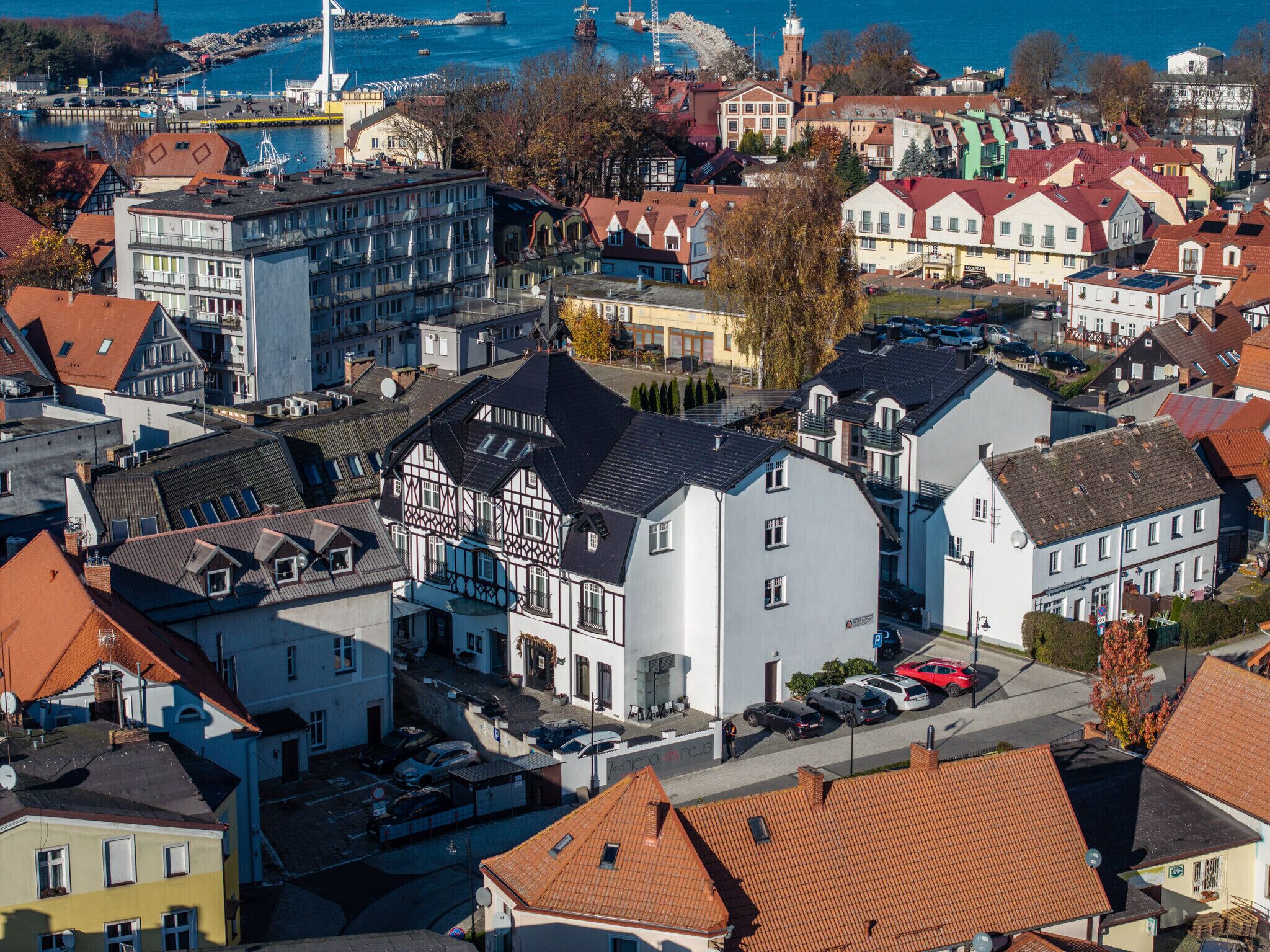 A town with a mix of traditional and modern buildings, including a prominent white building with a black roof.