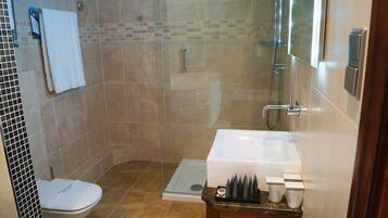 Un bagno con doccia, WC e lavandino con articoli da toilette.