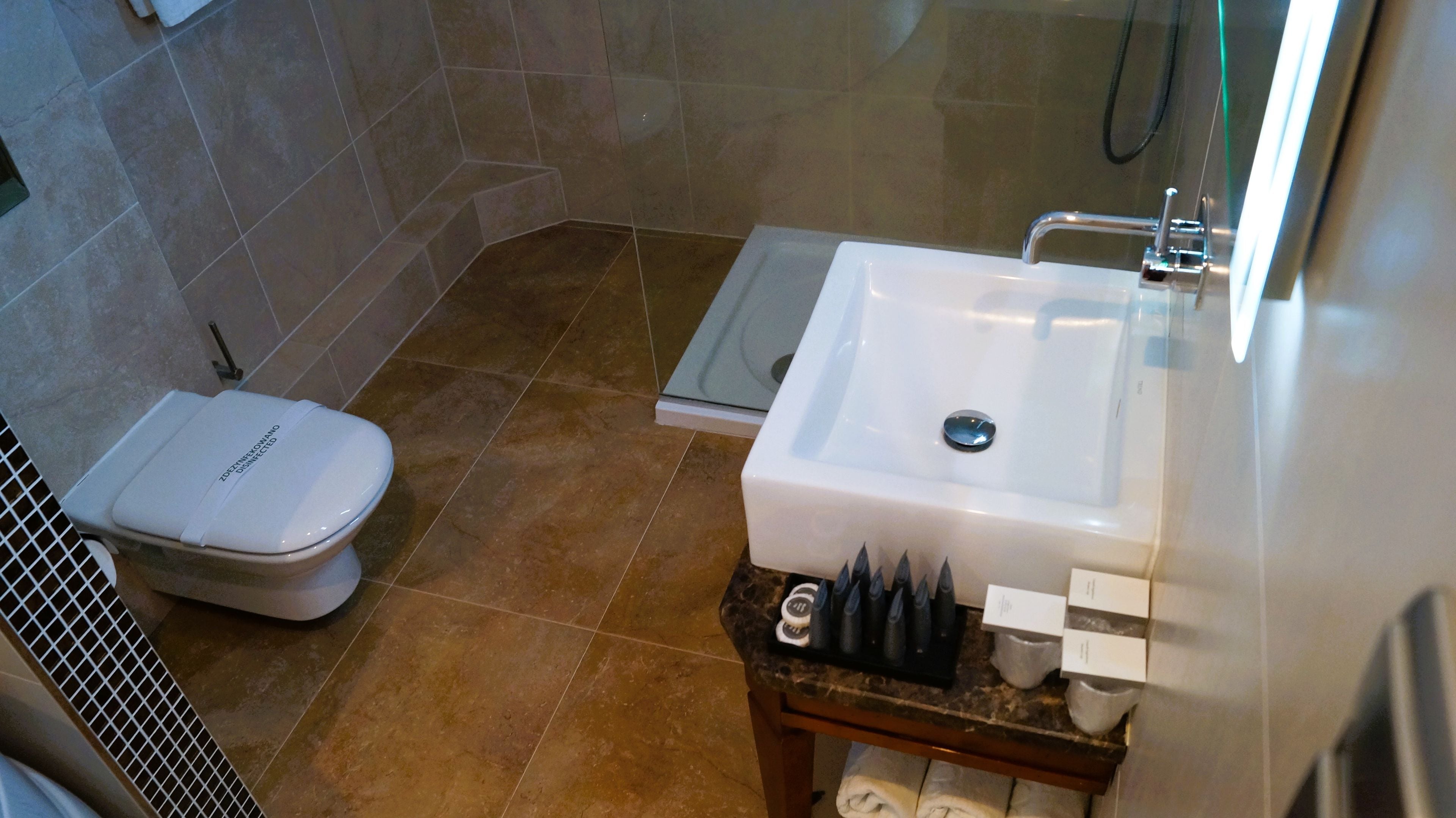 Ein Badezimmer mit Toilette, Waschbecken und Duschbereich.