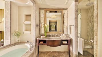 A luxurious bathroom with a marble sink, a bathtub, and a walk-in shower.