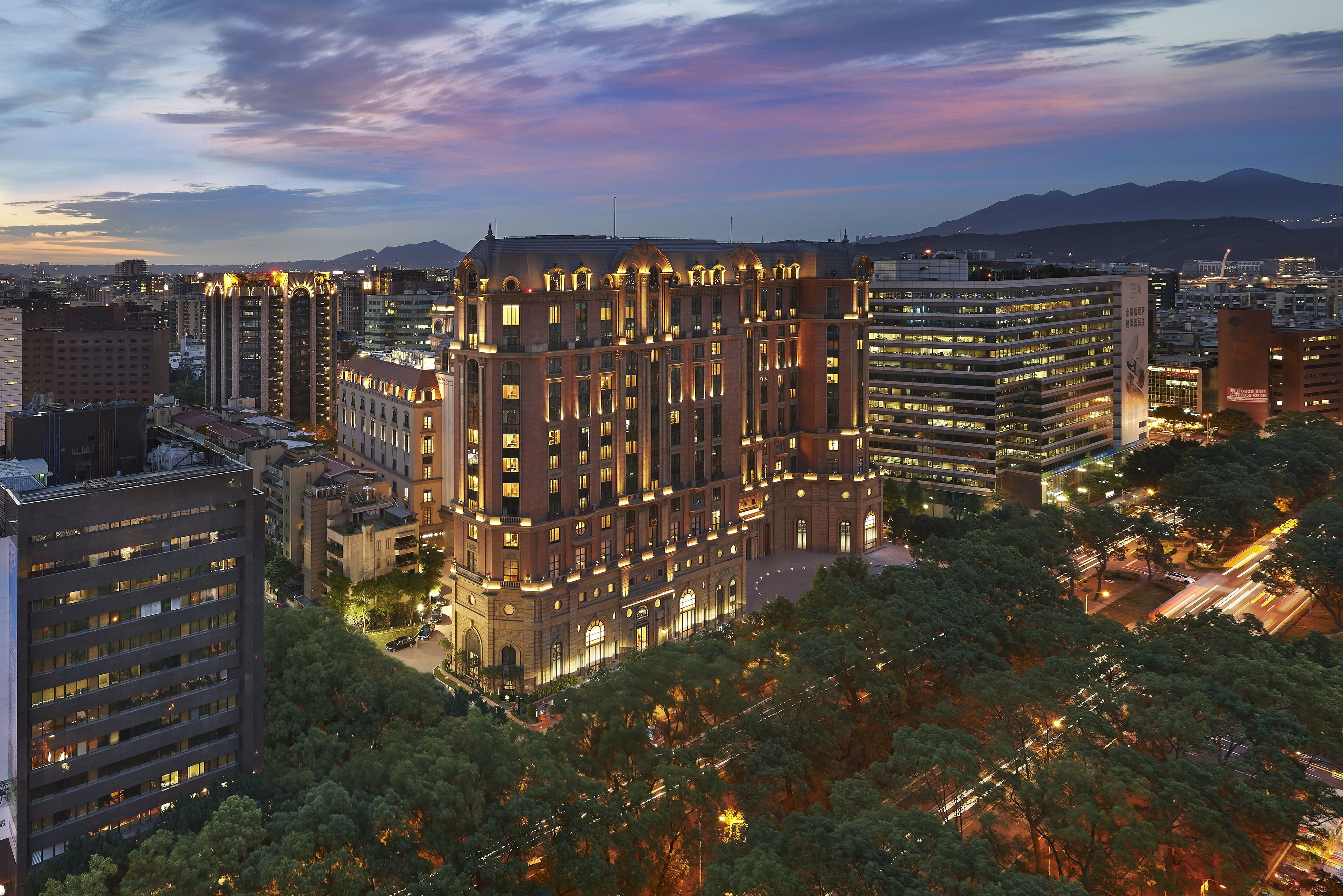 A multi-story building with a classic architectural design, surrounded by other high-rise buildings and trees.