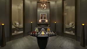 A modern hotel lobby with a central table displaying amenities, a chandelier, and mirrored walls reflecting the room. - Mandarin Oriental, Taipei (Taipei)