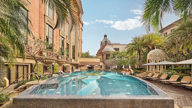A swimming pool with lounge chairs and palm trees, surrounded by buildings with classical architecture. - Mandarin Oriental, Taipei (Taipei)