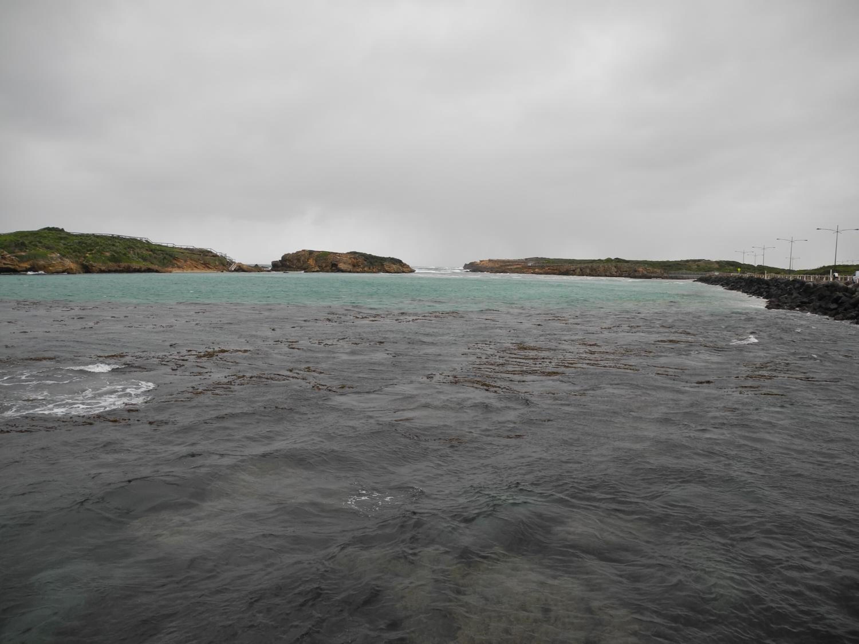 A coastal beach with rocky terrain and a view of the sea.