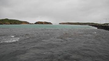 A coastal beach with rocky terrain and a view of the sea.