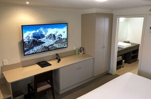 Escritorio, cortinas blackout y tabla de planchar con plancha 