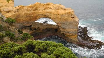Formación natural de arco de roca con vista al mar.