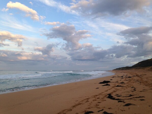A beach with a sandy shore and waves.