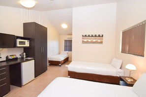 A hotel room with a kitchenette, two beds, a small refrigerator, and a bedside lamp. - Station Hotel Motel Kurri Kurri (Kurri Kurri)