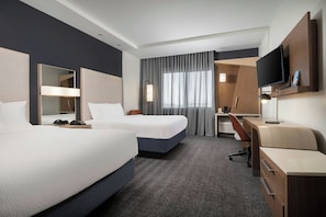 A hotel room with two beds, a desk, a TV, and a large window with curtains. - Courtyard by Marriott Houston NW/290 Corridor (Houston)