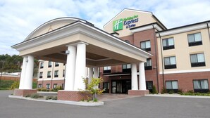 Ein Gebäude von Holiday Inn Express & Suites mit überdachter Einfahrt, Backsteinfassade und zahlreichen Fenstern.