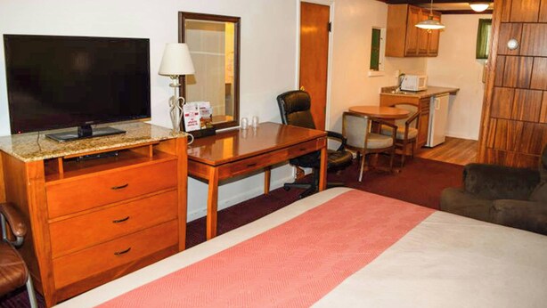 A hotel room with a bed, a desk with a computer, a chair, a television, and a microwave. - Relax Inn Bloomsburg (Bloomsburg)