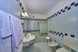 Kylpyhuone, jossa on kaksi pesuallasta, wc ja suihku.