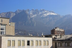 A building with multiple windows and a view of snow-capped mountains in the background.
