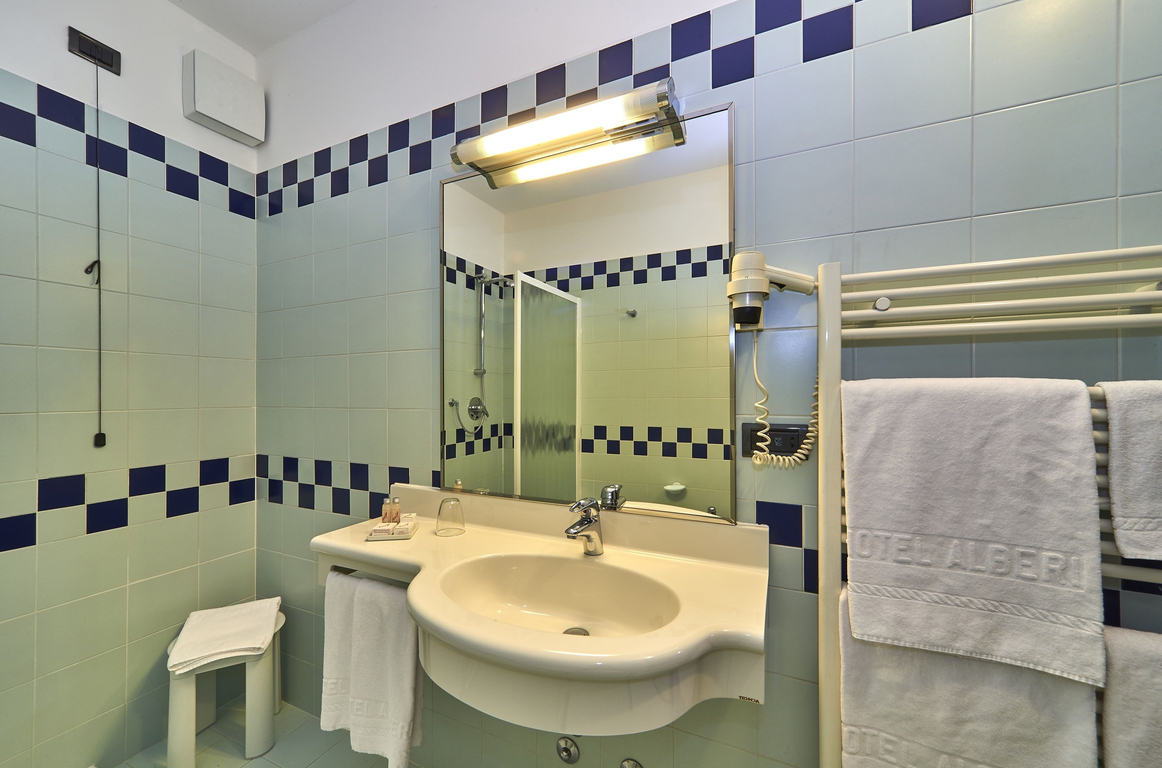 A bathroom with a sink, mirror, and towel rack.