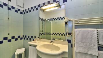 A bathroom with a sink, mirror, and towel rack.
