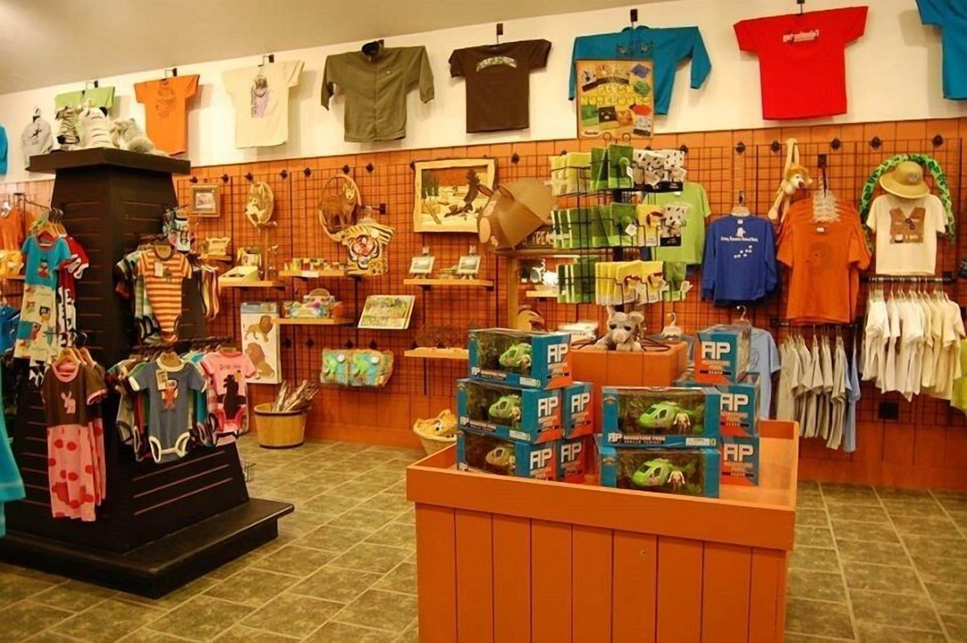 A clothing store with various apparel items on display, including t-shirts, shorts, and children's clothing.