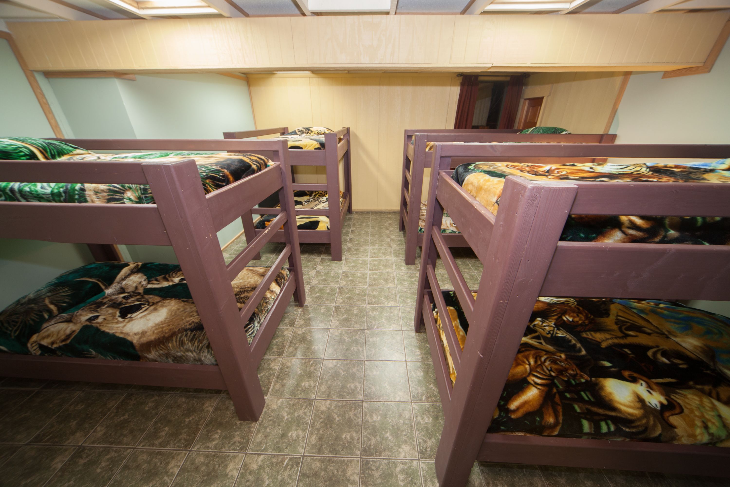 Quarto com beliches, cada um com colcha estampada.