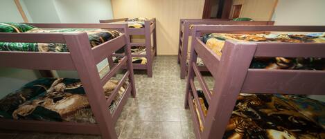 Quarto com beliches, cada um com colcha estampada.