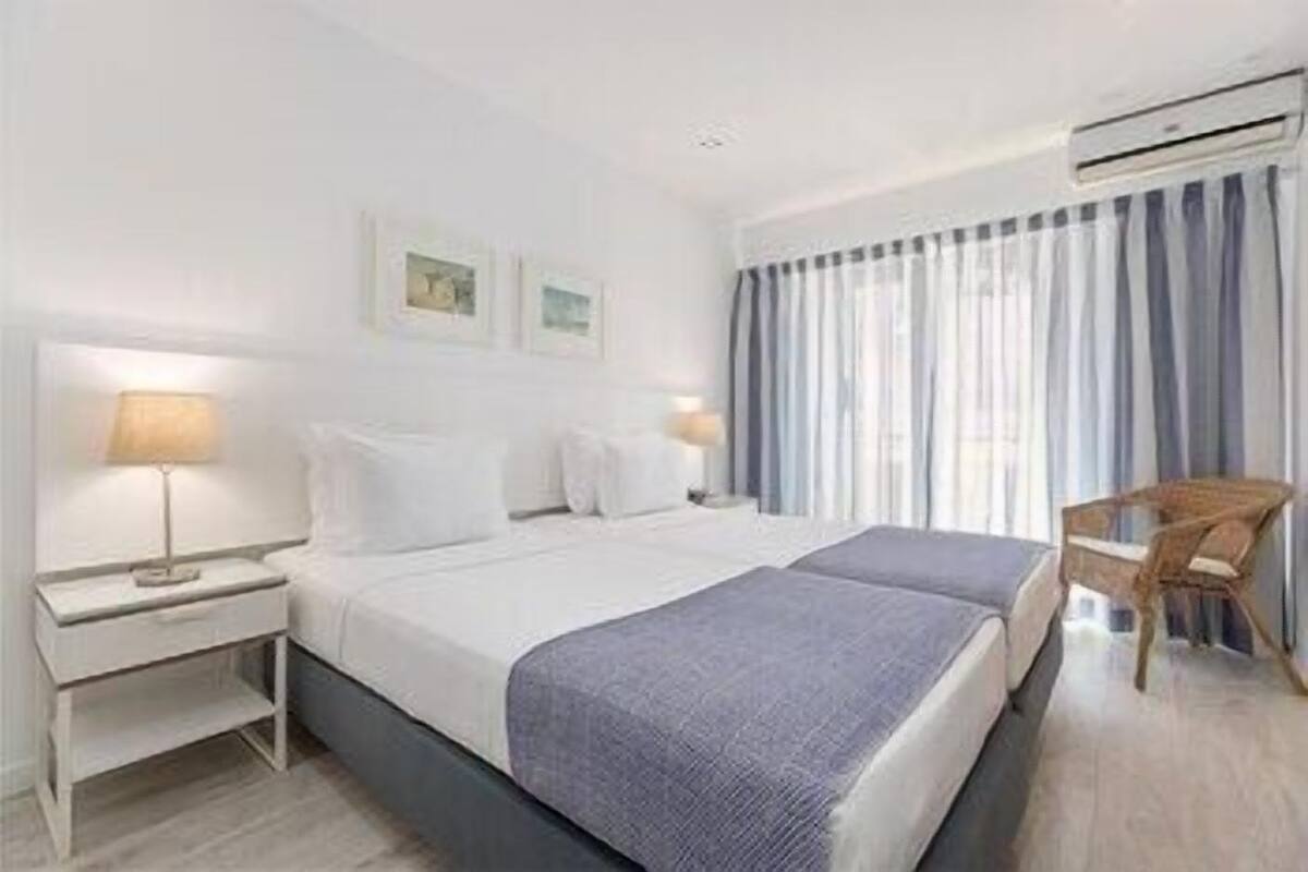 Ett hotellrum med en säng, sängbord, ett skrivbord och en stol.