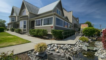 A two-story house with a large front porch, a small front yard with a rock garden, and a visible sign for Sunrise Inn.