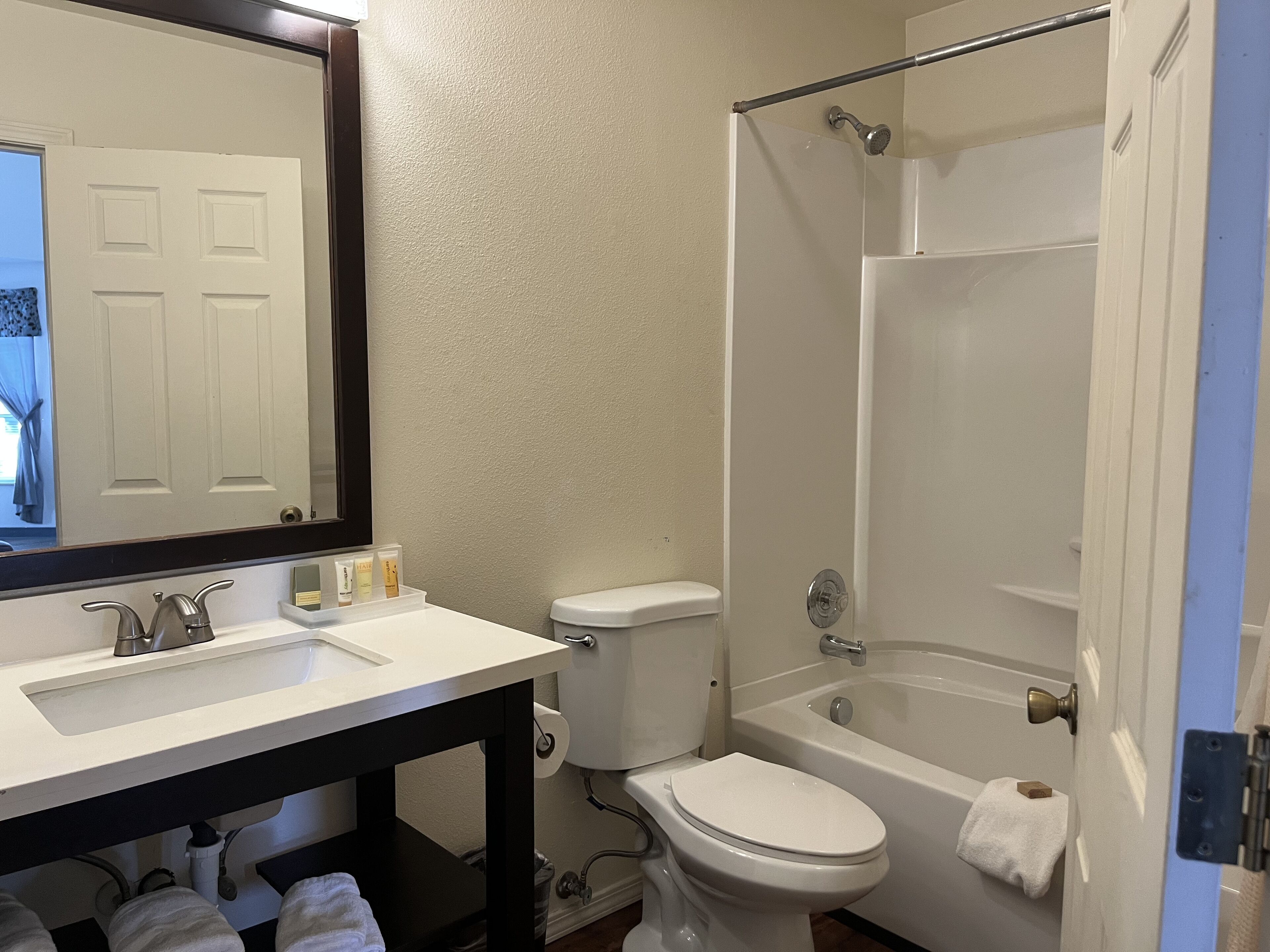 Un baño con lavamanos, inodoro y bañera blancos.