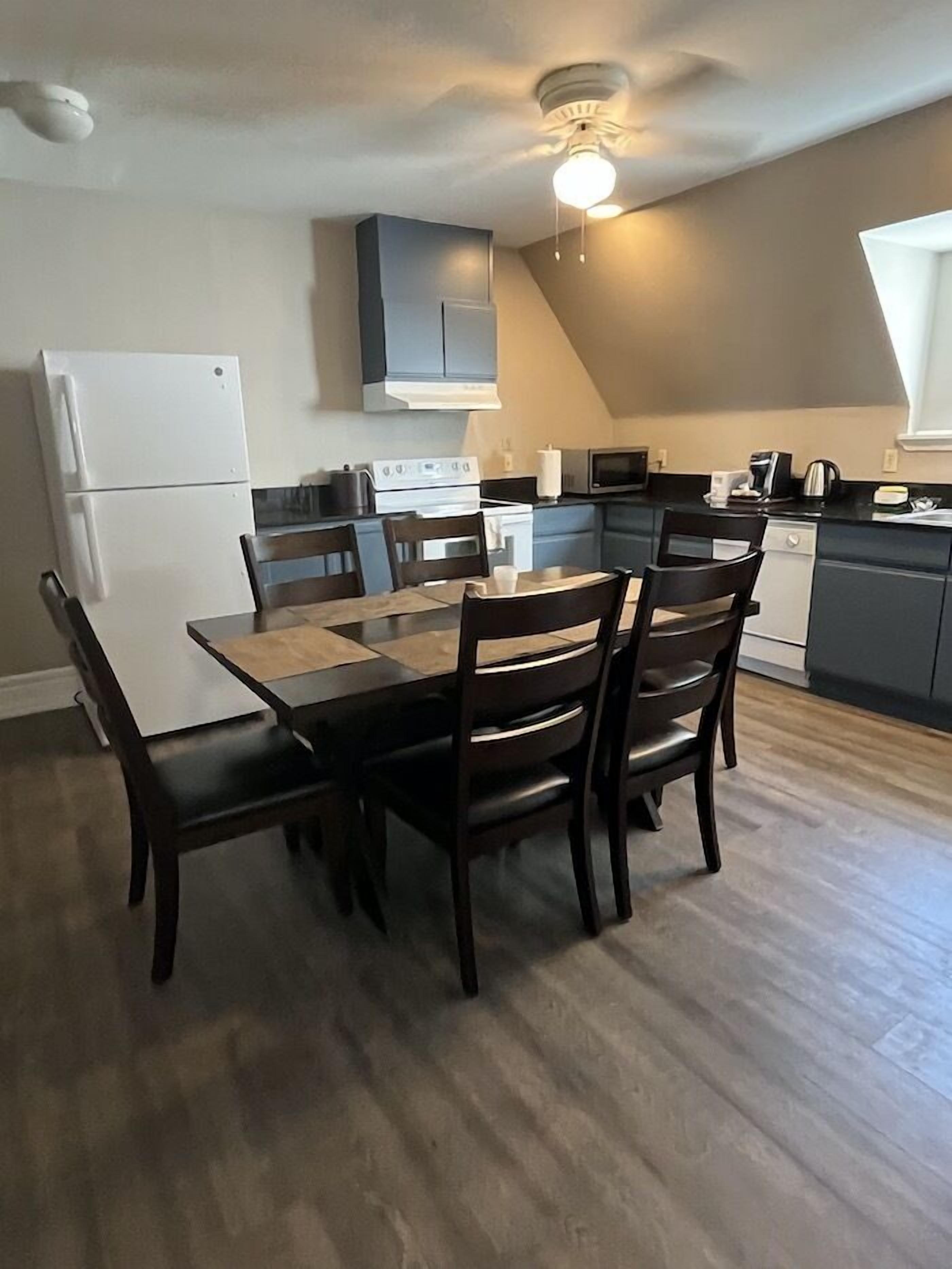 Una cucina moderna con zona pranzo. Dispone di frigorifero, piano cottura, forno a microonde e pensili.