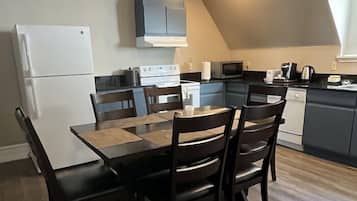 Una cucina moderna con zona pranzo. Dispone di frigorifero, piano cottura, forno a microonde e pensili.