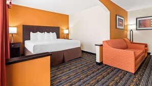 A hotel room with a bed, a sofa, a nightstand, and a lamp. - Best Western Kenosha Inn (Broken Arrow)