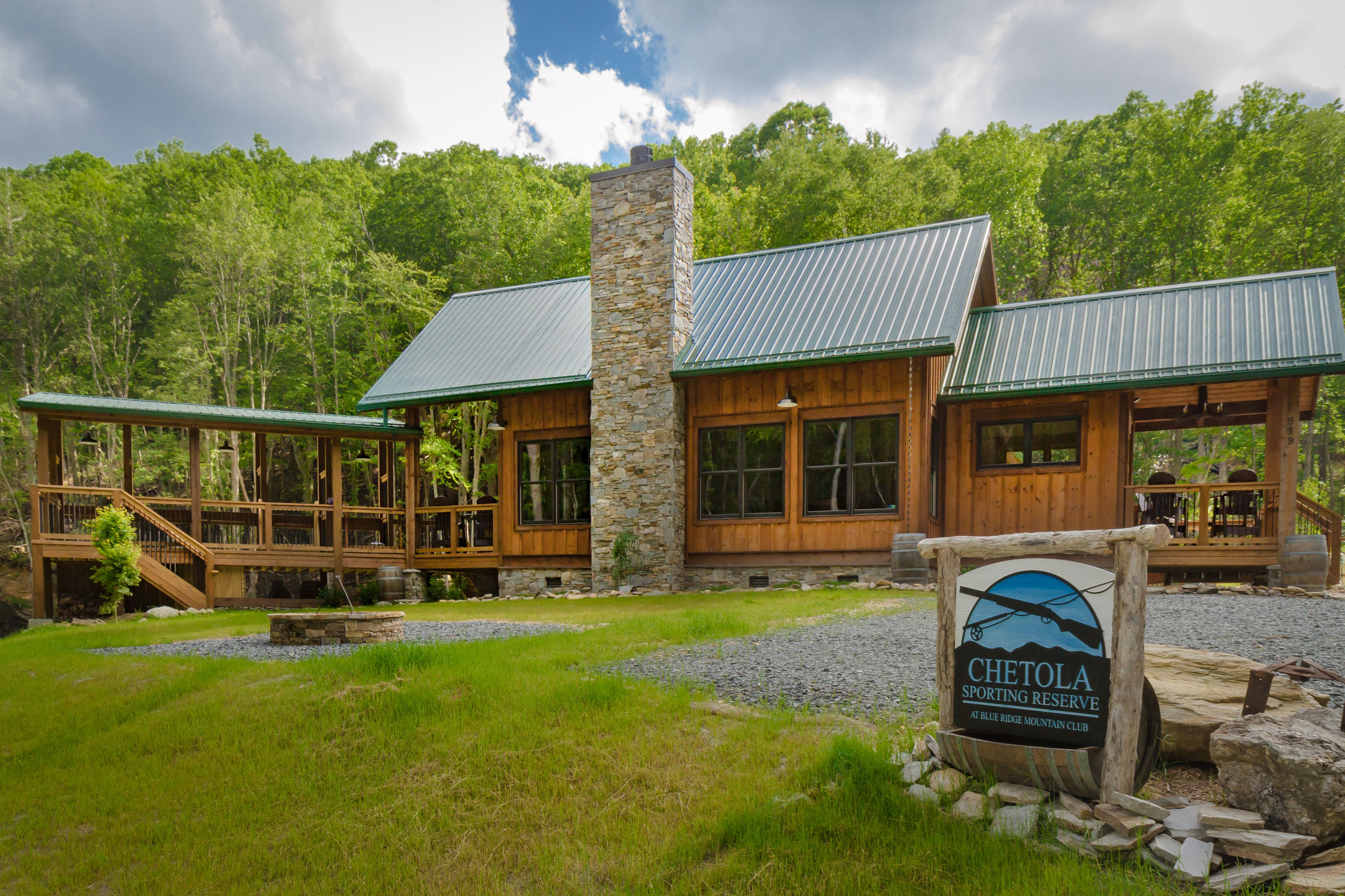 Eine Lodge mit Steinkamin, Holzausbau und einem Schild für Chetola Sporting Reserve.