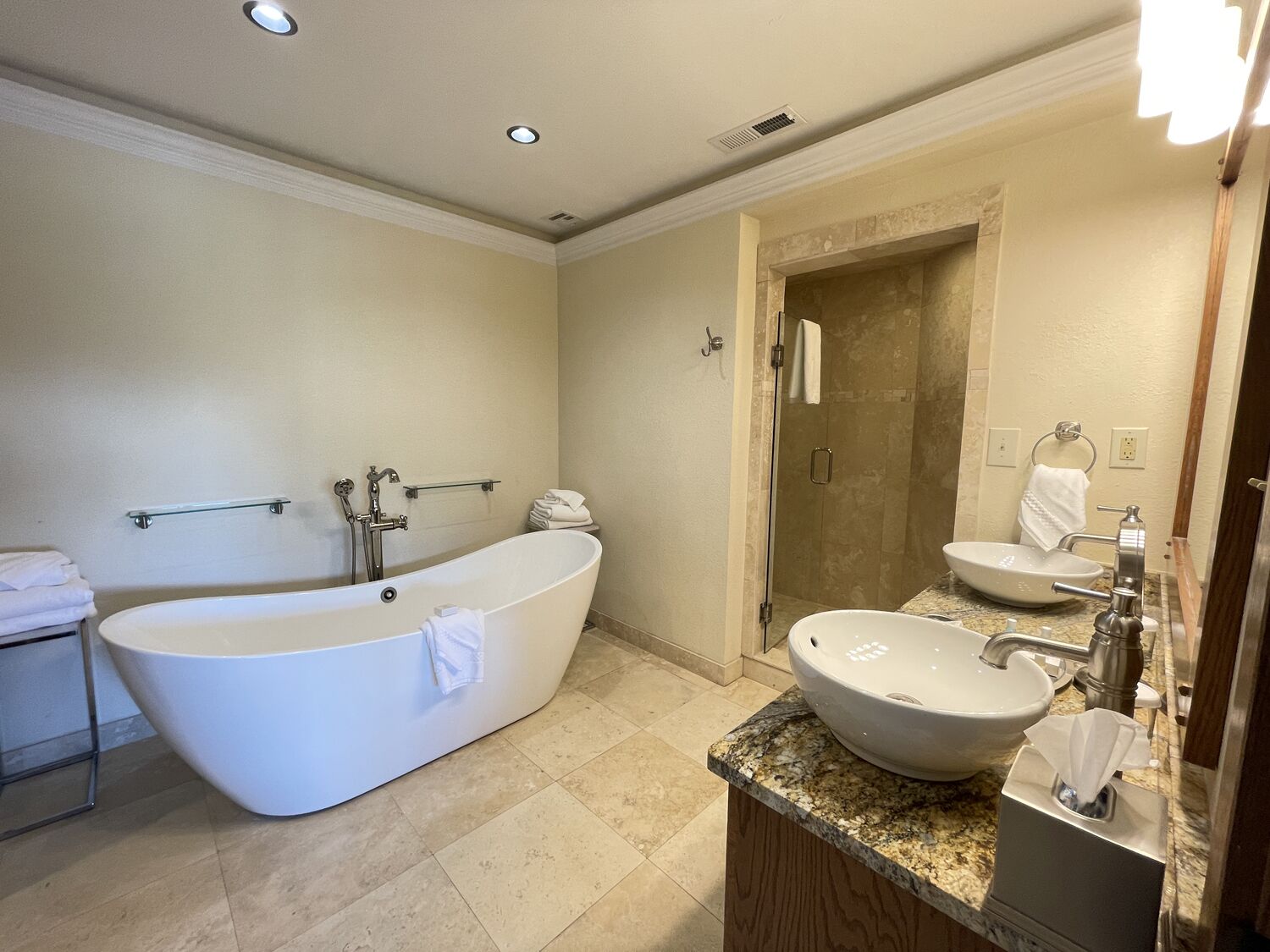 A modern bathroom with a freestanding bathtub, a separate shower area, and a vanity with a sink and mirror.