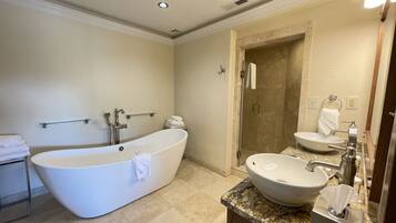 A modern bathroom with a freestanding bathtub, a separate shower area, and a vanity with a sink and mirror.