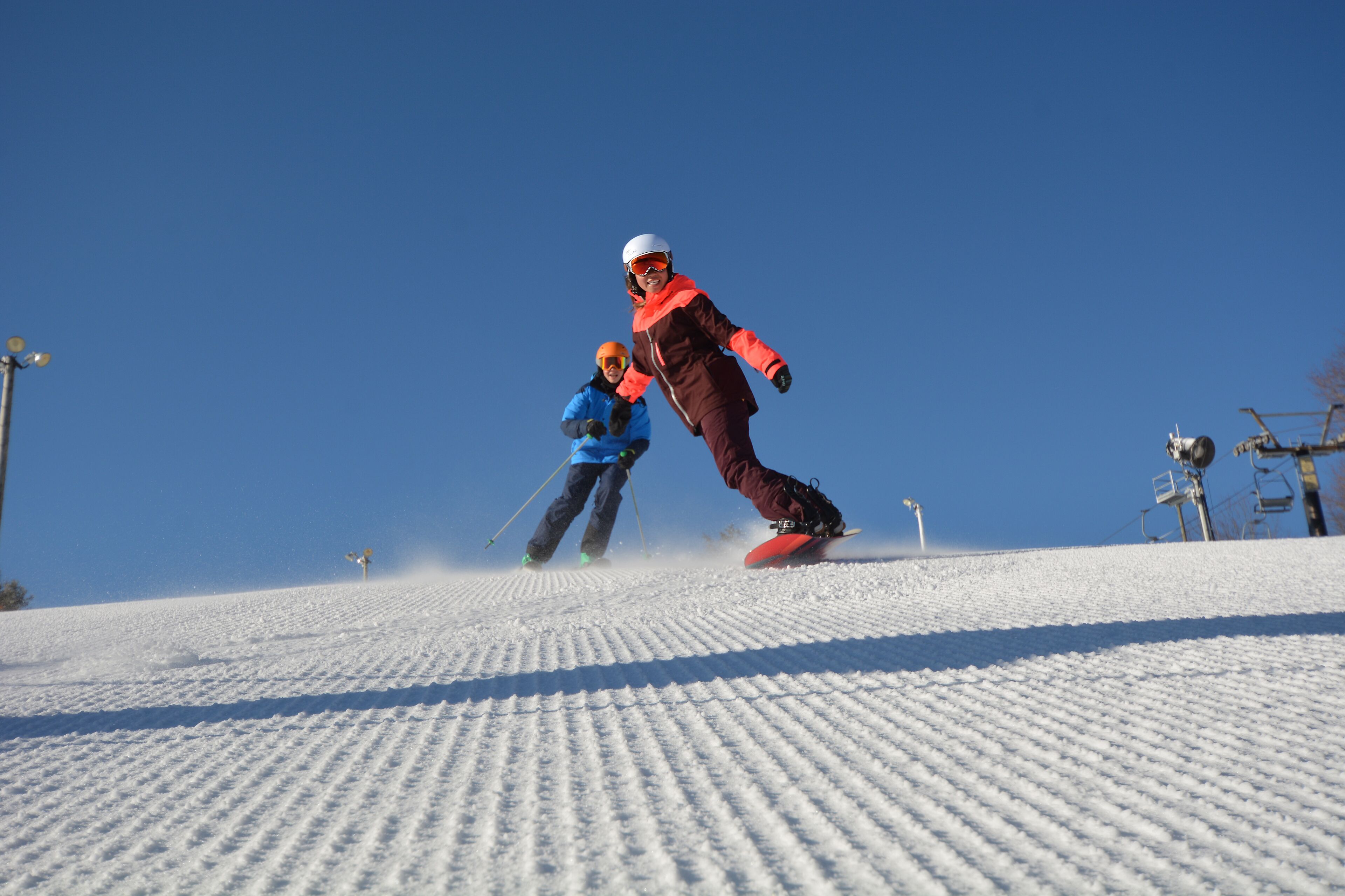 Une piste de ski enneigée avec deux skieurs.