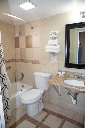 A bathroom with a bathtub, toilet, and sink.