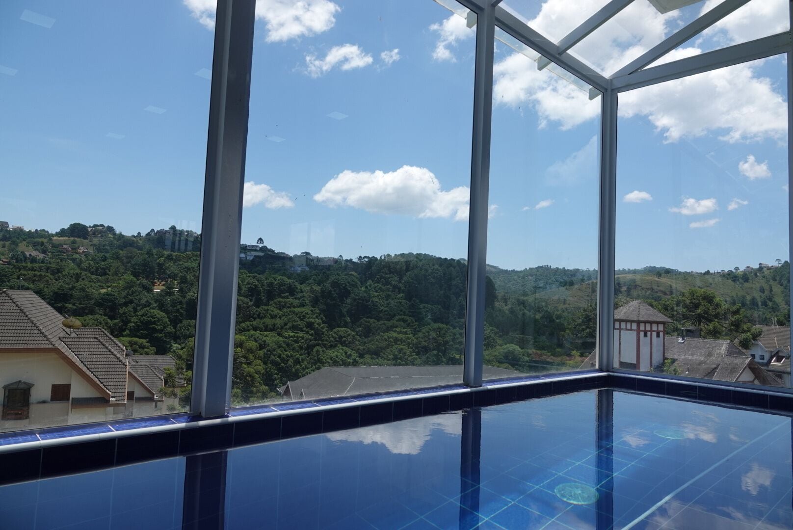 Una piscina con vistas despejadas a una colina y edificios al fondo.