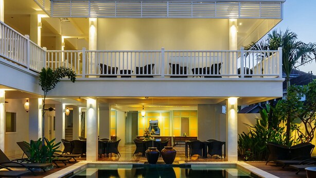 A multi-story hotel with a swimming pool, balconies, and outdoor seating areas. - Samsara Inn (Kuta)