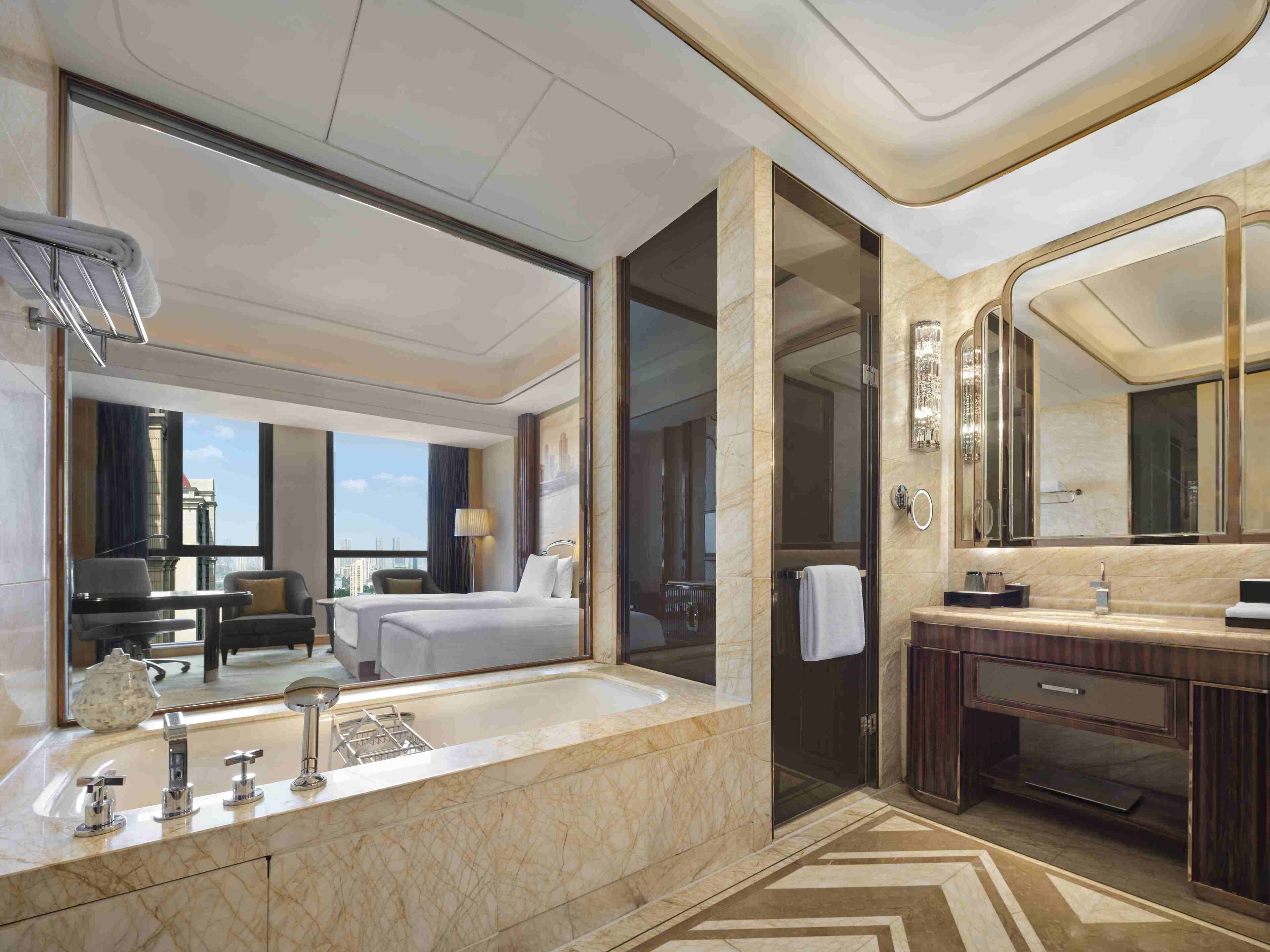 A modern hotel bathroom with a large marble sink, a separate shower area, and a large mirror.