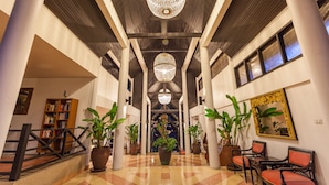A spacious lobby with a high ceiling, large chandeliers, and potted plants. - Kamala Beach Estate (Kamala)