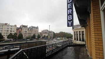 Vista de un paisaje urbano con un puente, edificios y un cartel que dice 'DERBY'.