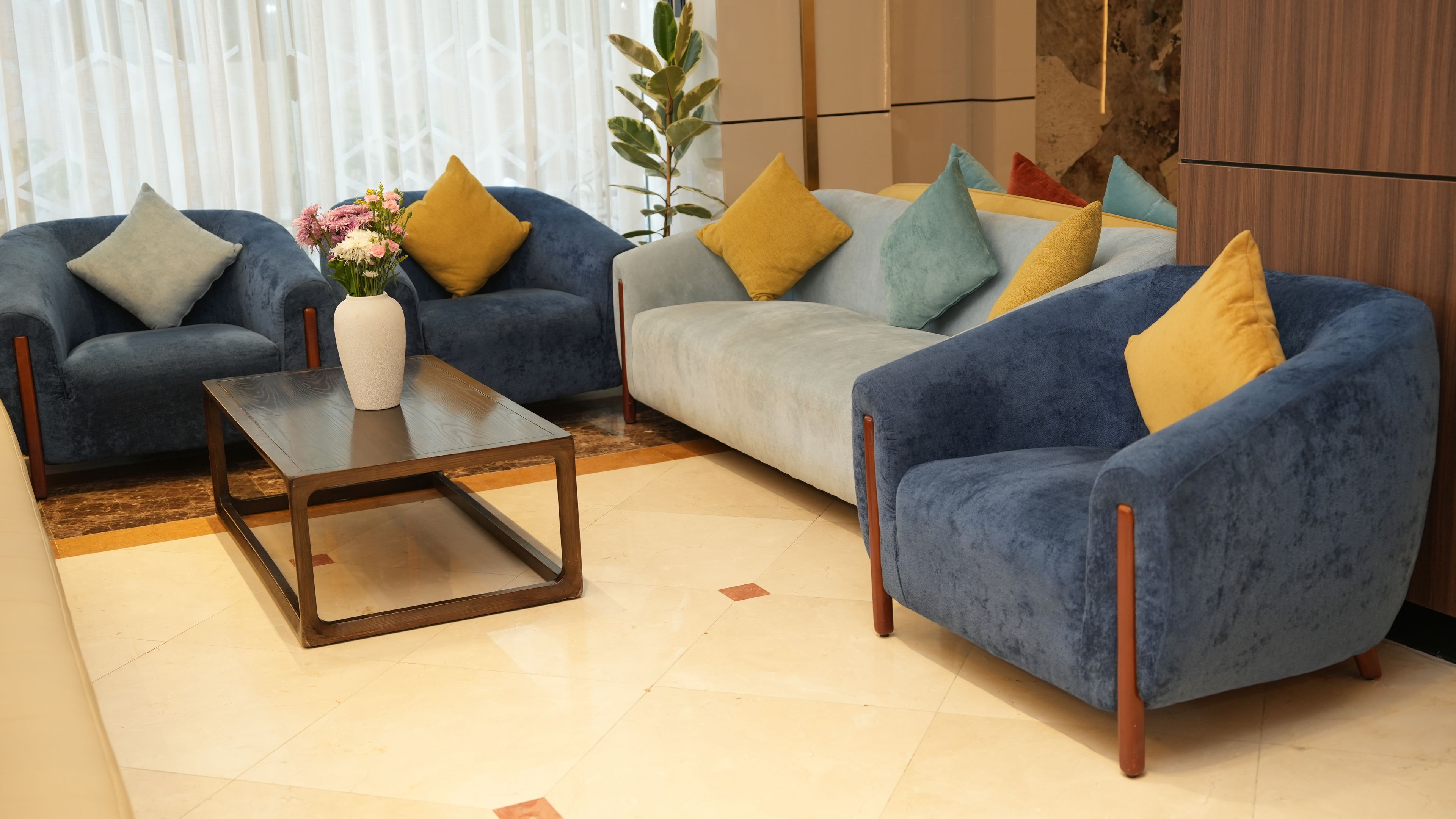 A living room with two sofas, a coffee table, and a vase of flowers.