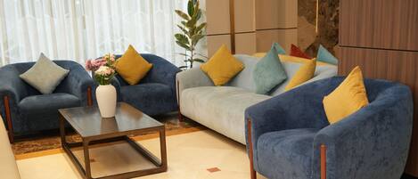 A living room with two sofas, a coffee table, and a vase of flowers.