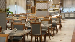Un restaurante con varias mesas y sillas dispuestas en filas.