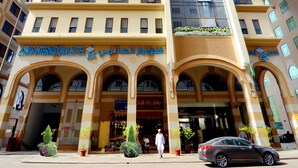 Un hotel con una amplia fachada de vidrio, varios balcones y una entrada destacada con arcos.