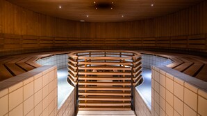 Sauna amb interior de fusta, parets revestides de rajola i zona central amb seients.