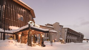 Un hotel amb façana de fusta, pilars de pedra i un rètol que diu "Sagara Land Hotel".