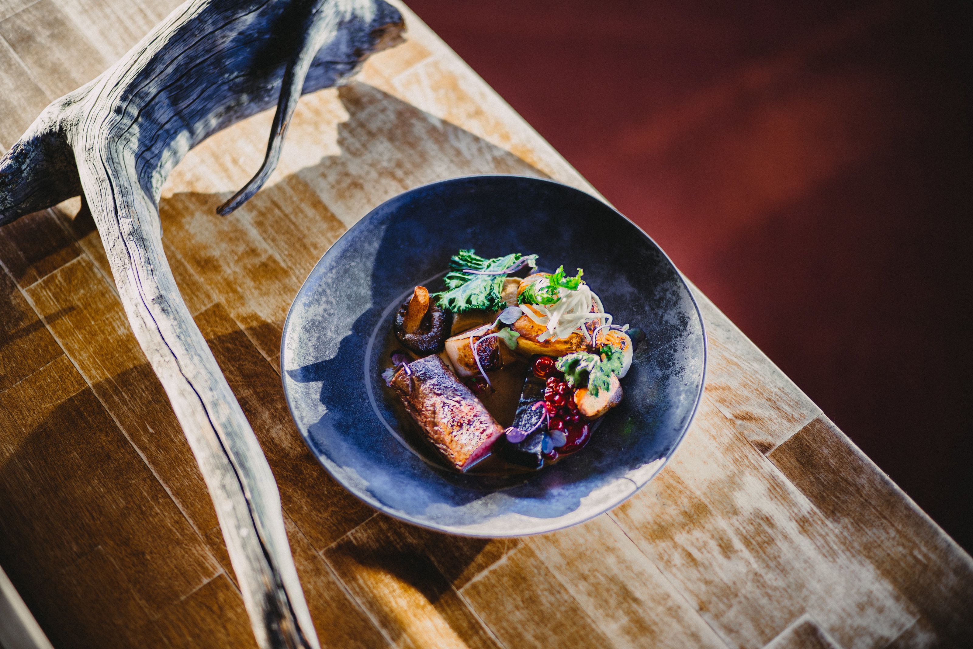 A bowl of food on a wooden table with a rustic design.