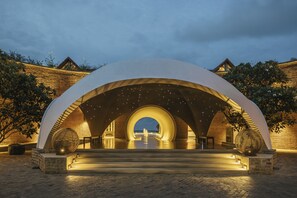 A modern architectural structure with a central dome and surrounding arches, leading to a viewing platform.