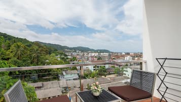 Un balcón con vistas a la ciudad y colinas.