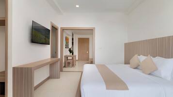 Una habitación de hotel con una cama grande, un televisor montado en la pared y un cabecero de madera.