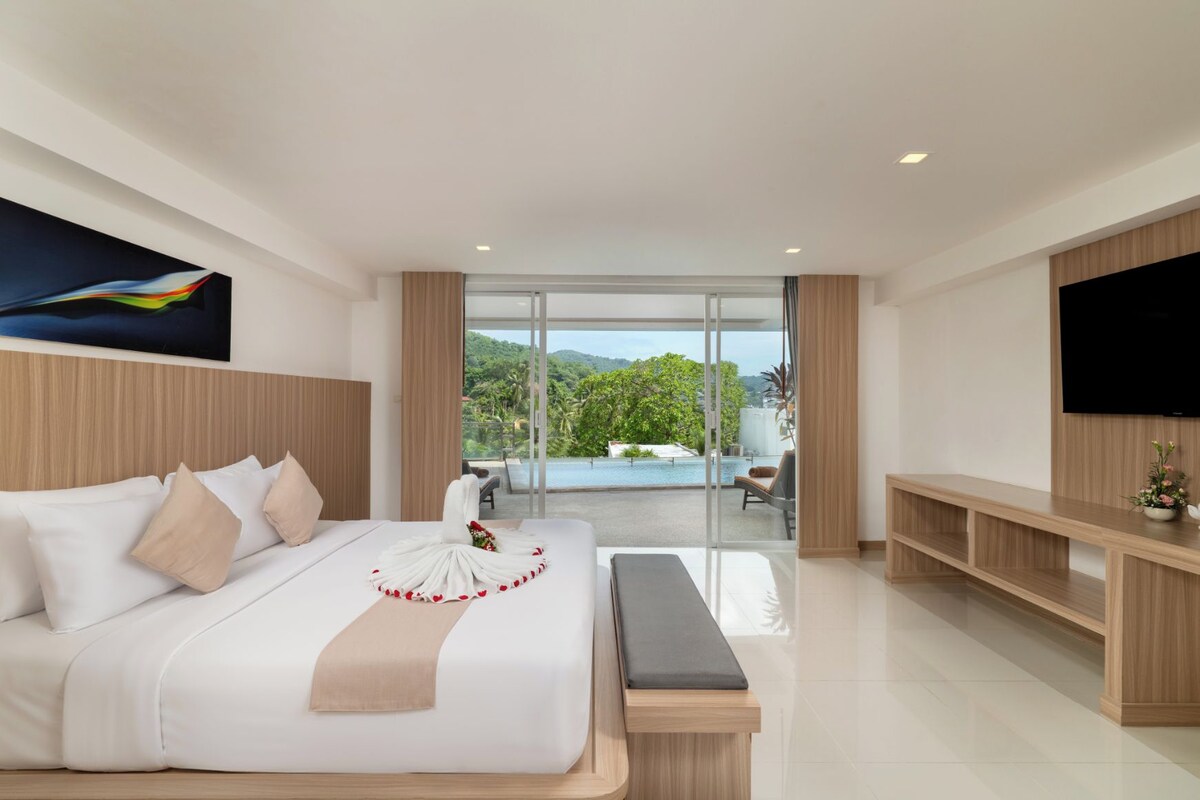 Ein modernes Hotelzimmer mit einem großen Bett, einem Flachbildfernseher, einem Balkon mit Blick auf den Pool und einem hölzernen Kopfteil.